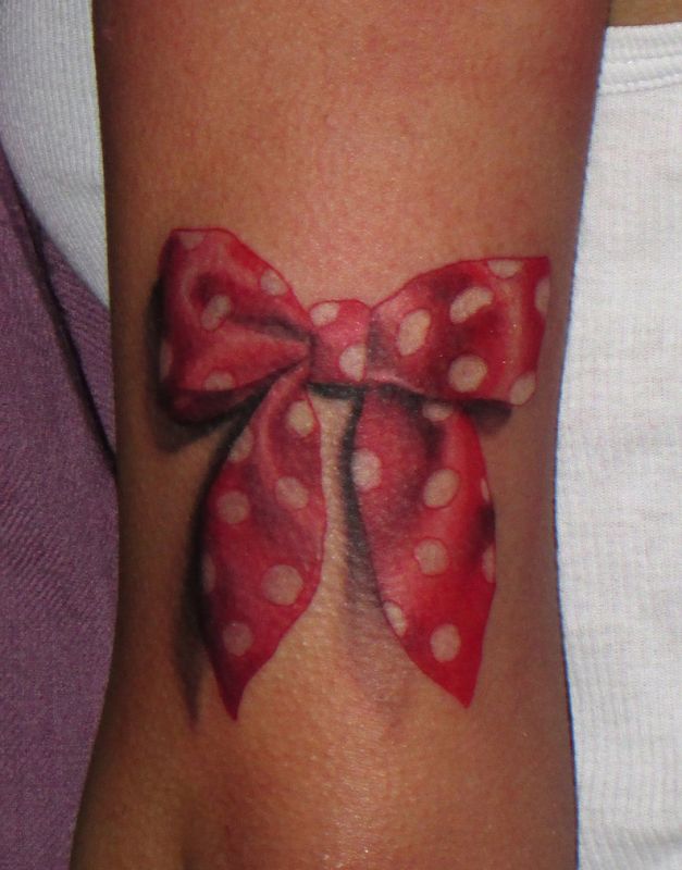 Red ribbon with white spots tattoo