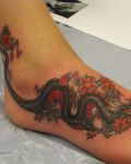 Black dragon and flowers tattoo