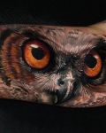 Owl with orange eyes tattoo