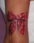 Red ribbon with white spots tattoo