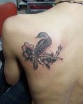 Small bird with two flowers tattoo
