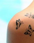Three black butterflies on the arm