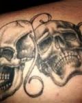 Two skulls mask tattoo
